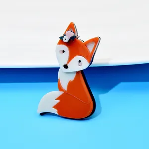 Close-up detail of a cute orange and white acrylic fox brooch with small floral headpiece