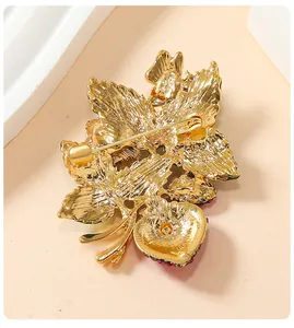 Detailed back view of a vintage gold-plated strawberry brooch showing pin mechanism