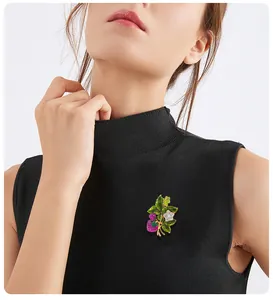 Macro detail shot of a vintage strawberry brooch pinned on a black turtleneck top