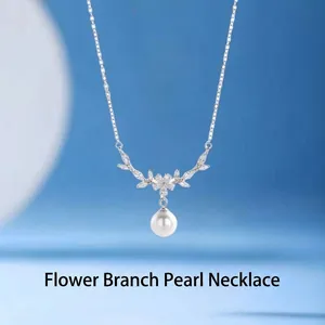 Detail view of silver floral branch necklace with an elegant white pearl pendant