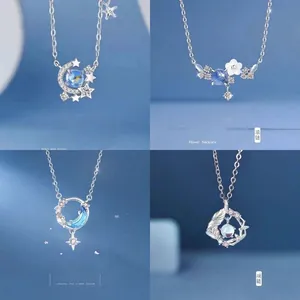 Fijne zilveren kettingen met hemelse en florale motieven op blauwe achtergrond