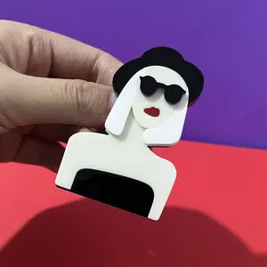 Eleganter Acryl-Anstecker mit einem stylischen Cartoon-Mädchen mit Hut und Sonnenbrille