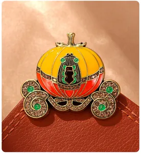 Close-up of an enamel pumpkin carriage brooch with sparkling rhinestones on leather