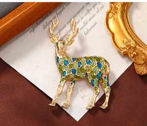 Détail macro d'une broche élan en émail avec cristaux verts sur fond de papier vintage