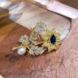 Detailed close-up view of a vintage sunflower brooch with white pearl and blue sapphire gemstone