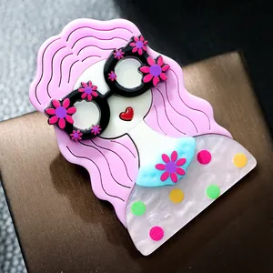 Gros plan d'une jolie broche de fille en acrylique avec cheveux roses et lunettes
