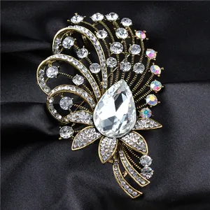 Macro view of luxury vintage crystal brooch with water-drop center on black satin fabric