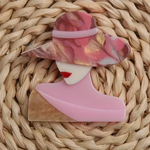 Close-up of an elegant acrylic lady brooch with a pink marble-textured hat.