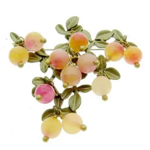 Vintage style cranberry branch brooch with green leaves and colorful berry beads.