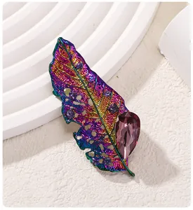 Elegante primo piano di una spilla a foglia arcobaleno con cristalli viola fini