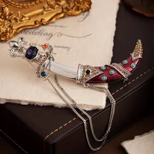 Close-up of a vintage court-style scimitar brooch with colorful gemstones and chain.