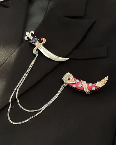 Detailed macro shot of vintage scimitar brooch with colorful gemstones on black suit