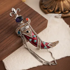 Detailed view of a vintage palace style dagger brooch with red enamel and crystals