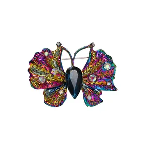 Squisita spilla a farfalla colorata iridescente con una grande gemma blu scuro al centro