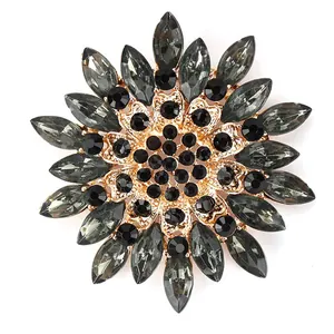Close-up of elegant snowflake brooch with grey glass crystals and gold-tone finish