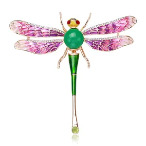 Detail of a colorful enameled dragonfly brooch with sparkling rhinestone accents and green stone