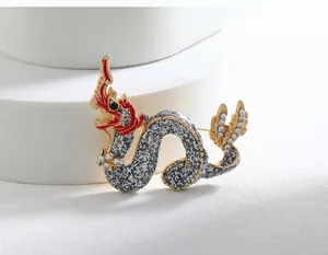 Detail of a vintage Chinese zodiac dragon brooch with red enamel and grey glitter.