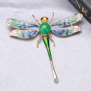 Detailed macro view of a colorful enamel dragonfly brooch featuring sparkling crystals