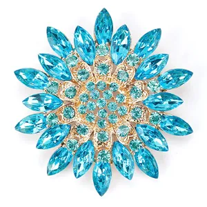 Close-up macro view of sparkling blue crystal snowflake brooch with gold setting details
