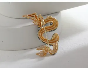 Macro detail showing the back view of vintage gold dragon brooch with secure clasp