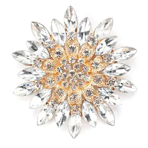 Close-up of an elegant glass crystal flower brooch with shimmering petals on gold plating.