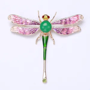 Close-up detail of a colorful enamel dragonfly brooch featuring sparkling crystal accents