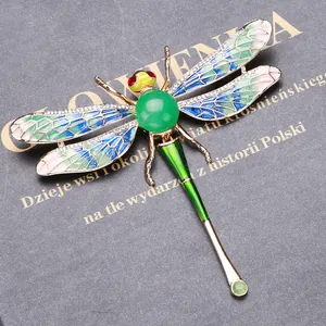 Close-up of artistic enamel dragonfly brooch with sparkling rhinestone accents