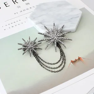 Macro view of starburst brooch with sparkling rhinestones and delicate tassel chains