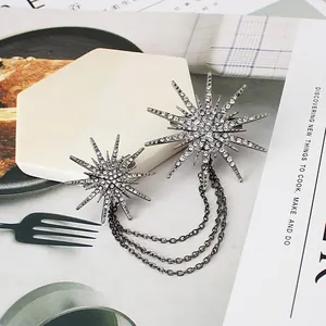 Close-up of sparkling starburst brooch with rhinestone-encrusted tassel chains.