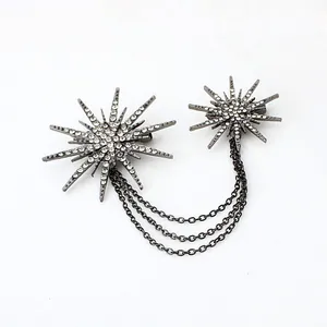 Detailed view of rhinestone encrusted starburst brooch with delicate chain tassels