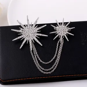 Detailed view of silver starburst brooch with rhinestone-encrusted tassels