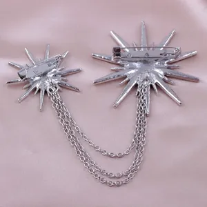 Detailed back view of a silver starburst chain brooch showing the pin mechanism and chains.