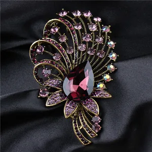 Elegant palace style vintage brooch with large purple teardrop crystal on black silk fabric