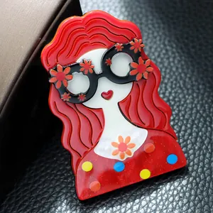 Gros plan d'une jolie broche en acrylique représentant une fille aux cheveux roux