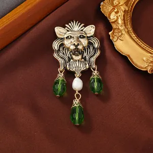 Detailed macro shot of vintage lion head brooch featuring green crystal droplets and pearl
