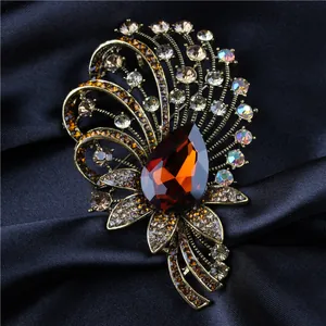 Vintage palace style crystal brooch with amber pear-shaped stone on silk background