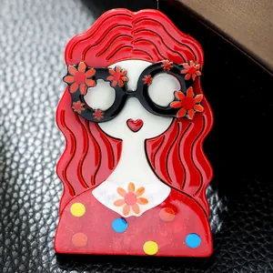 Broche en acrylique représentant une fille rousse avec lunettes à fleurs