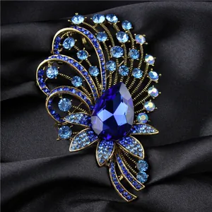 Elegant palace style brooch featuring blue teardrop crystal and gold-tone metal finish
