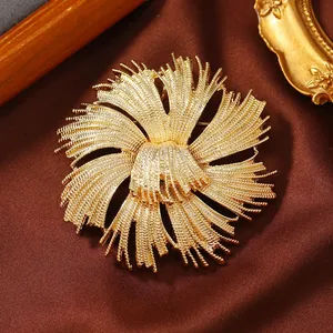 Close-up of vintage golden starburst brooch with intricate woven texture on brown silk