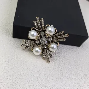 Detailed macro view of a vintage cross brooch with elegant pearls and sparkling rhinestones