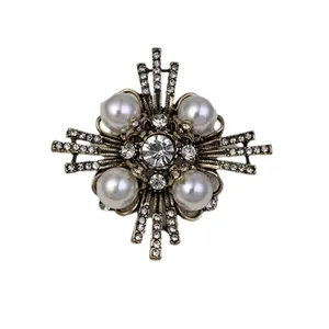 Vintage geometric cross brooch with pearls and sparkly rhinestones for elegant styling.