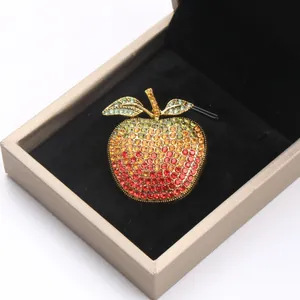 Detailed close-up of a vibrant gradient rhinestone apple brooch inside a black gift box