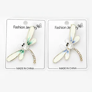 Detailed view of fashion dragonfly brooches with pearls and rhinestones on cards