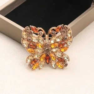 Vue détaillée d'une élégante broche papillon en strass avec des cristaux de couleur ambre