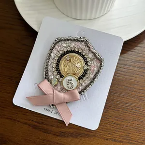 Elegant vintage pink bow brooch with sparkling crystals and number 5 for stylish coats