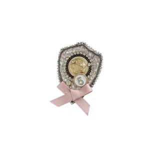 Elegant vintage pink bow brooch with rhinestone number 5 and gold tweed badge