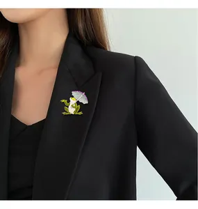 Detail shot of a creative frog brooch with an umbrella pinned on a black blazer