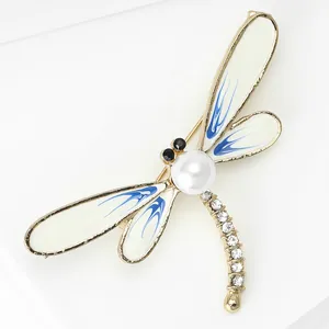 Macro view of an elegant dragonfly brooch with large white pearl and rhinestones