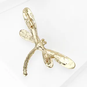 Back view detail of a gold dragonfly brooch with a secure safety pin mechanism for coats