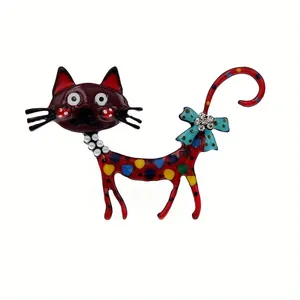 Gedetailleerd zicht op creatieve kleurrijke kattenbroche met stippen en kristallen strik